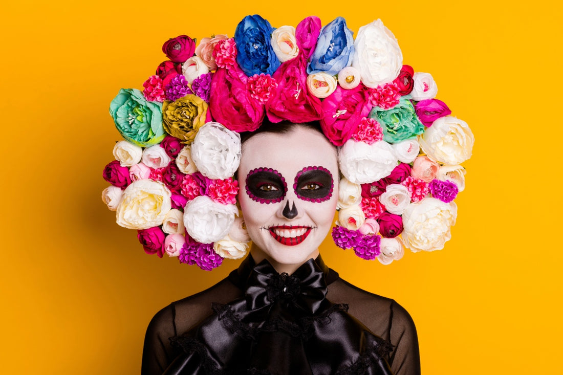 Women smiling with Day of the death or die de metros costume with facial theme and flowers on her head